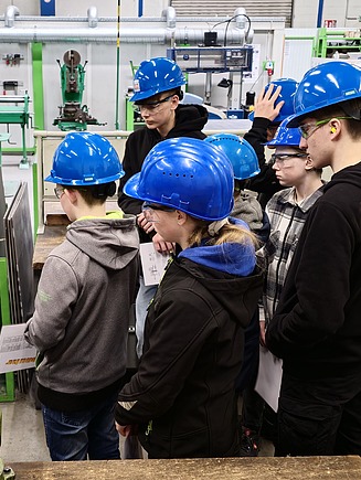 Kinder in Arbeitsschutzkleidung in der Produktionshalle von ZÜBLIN Stahlbau.