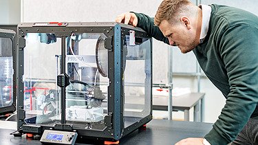 ZÜBLIN Mitarbeiter schaut in 3D Drucker
