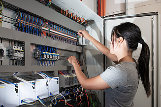 Ausbildung Anlagenmechaniker:in Eine junge Frau arbeitet an einer technischen Anlage.
