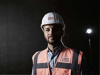 Profi Portraitfoto eines Poliers mit Warnweste und Bauhelm