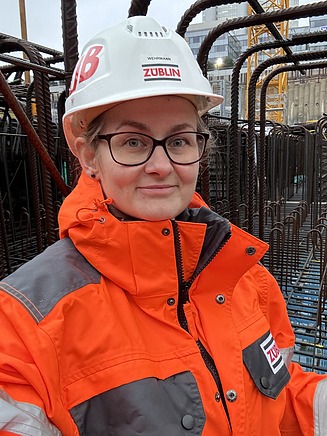 Selfie von Jasmin in Arbeitssicherheitskleidung auf einer Baustelle