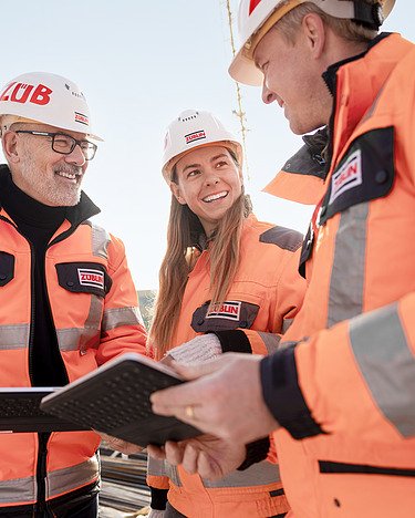 People on the building site are standing together.