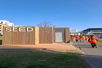Kinder in Arbeitsschutzkleidung laufen zu einer ZÜBLIN Baustelle.