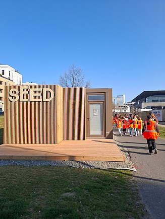 Kinder in Arbeitsschutzkleidung laufen zu einer ZÜBLIN Baustelle.