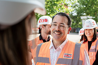 Photo of several ZÜBLIN colleagues standing on a building site