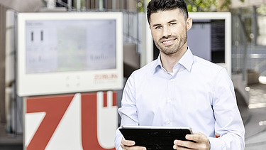 Foto von einem Mann, der ein Tablet hält und lächelt  