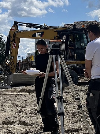Anh Thu carrying out surveying work on a building site