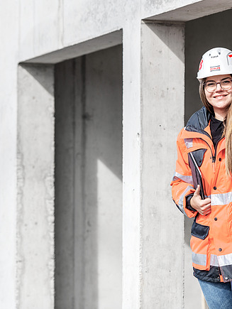 Foto von einer Frau mit Bauhelm und Schutzkleidung