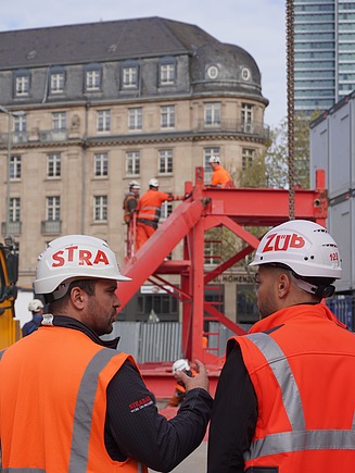 Joshua bespricht sich mit einem Kollegen auf der Baustelle
