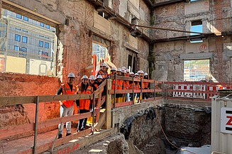Kinder in Arbeitsschutzkleidung stehen auf einer Baustelle