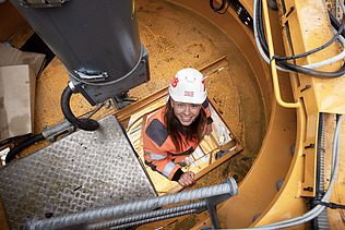 Photo of a female site manager climbing onto the construction crane