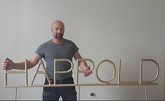 Mike mit seinem Nachnamen aus goldenem Stahl in der Hand