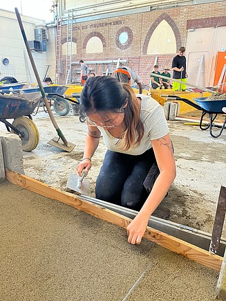Anh Thu in the training workshop, building a wall