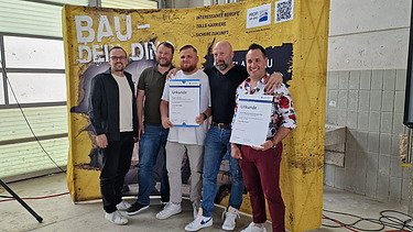 Oberpolier Mike bei der feierlichen Vergabe der Abschlusszertifikate zur Polierausbildung Arm in Arm mit 4 Kollegen