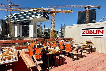 Kinder in Arbeitsschutzkleidung auf einer Baustelle