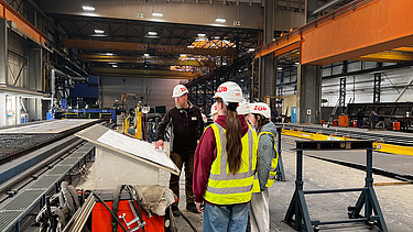 Kinder in Arbeitsschutzkleidung im Stahlwerk