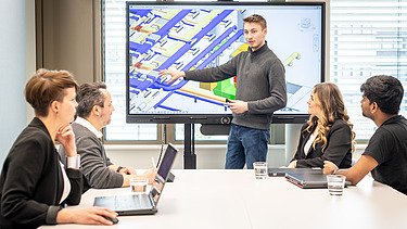 Fünf Kolleg:innen in einer Besprechungssituation im Büro