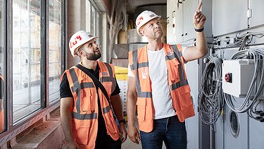 Foto von zwei ZÜBLIN-Kolleg:innen, die auf einer Baustelle stehen