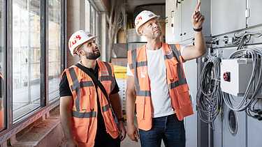 Photo of two ZÜBLIN colleagues standing on a building site