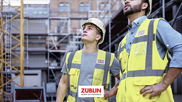 Foto von zwei Polieren, die sich gerade etwas auf der Baustelle ansehen.