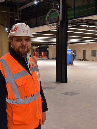 Junger Mann in Arbeitsschutzkleidung auf einer Baustelle