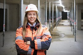Foto von einer Bauleiterin, die im Untergeschoss einer Baustelle steht