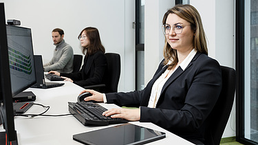 A ZÜBLIN employee, concentrating as she looks at a computer screen and works.