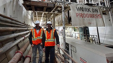 Two staff members wearing high-visibility clothing in the tunnel