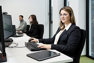 A ZÜBLIN employee, concentrating as she looks at a computer screen and works.