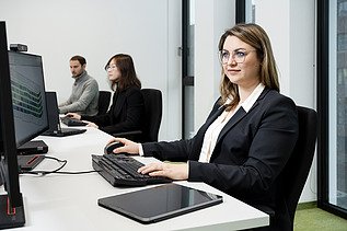 A ZÜBLIN employee, concentrating as she looks at a computer screen and works.