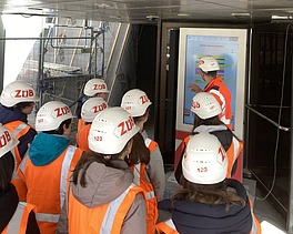 Kinder in Arbeitsschutzkleidung auf einer Baustelle