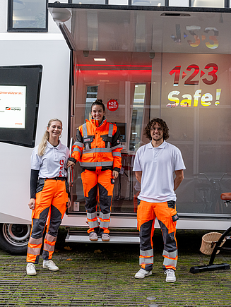 Drei Mitarbeiter:innen mit gebrandeten Trinkflaschen in der Hand