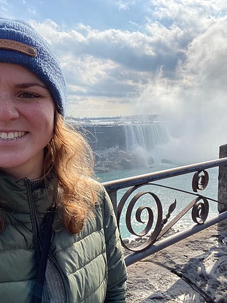 Selfie einer jungen Frau, im Hintergrund die Niagarafälle.