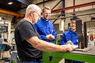 Zwei Auszubildende und ein Ausbilder in der Werkstatt
