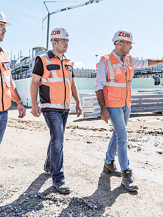 Foto von drei Mitarbeitern auf der Baustelle