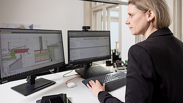 Foto von einer Projektleiterin, die gerade am PC arbeitet