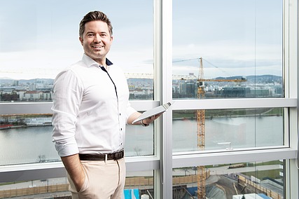 Mitarbeiter steht vor Fensterfläche