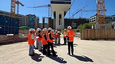 Kinder in Arbeitsschutzkleidung auf einer Baustelle