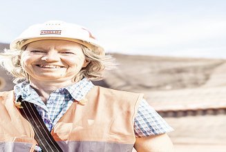 Foto Mann mit Helm und verschränkten Händen schaut nach oben rechts