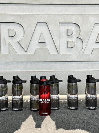 Bild von gebrandeten Trinkflaschen vor dem STRABAG-Logo
