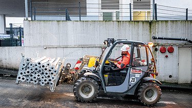 Mitarbeiter in einem Staplerfahrer auf der Baustelle