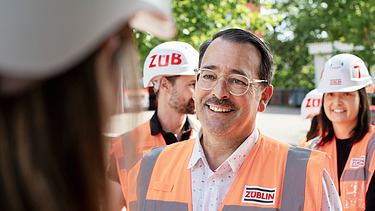 Photo of several ZÜBLIN colleagues standing on a building site