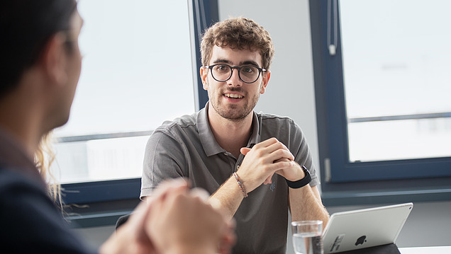 Junger Mann in Arbeitsschutzkleidung auf einer Baustelle.