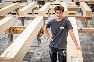 Mitarbeitender zwischen Holzelementen