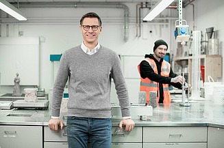 Experte für Betontechnologie Bild eines Mitarbeiters am Arbeitsplatz im Labor mit Kollegen