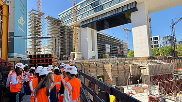 Children wearing high-visibility clothing on a building site
