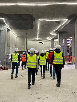 Bild einer Gruppe von Menschen, die eine Baustelle besichtigt 