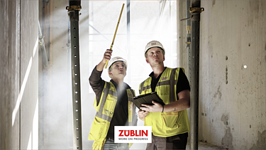 Foto von zwei Polieren auf der Baustelle, die sich gerade den Baufortschritt ansehen.