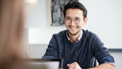 Junger Mann in Arbeitsschutzkleidung auf einer Baustelle.