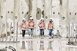 Foto von vier Personen in Schutzkleidung auf einer Baustelle
